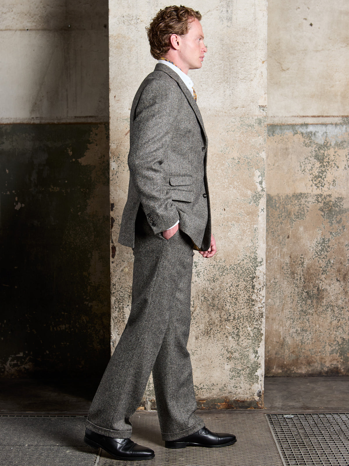 Dark Grey herringbone tweed suit in Moon Tweed, side view while walking – John Crocket
