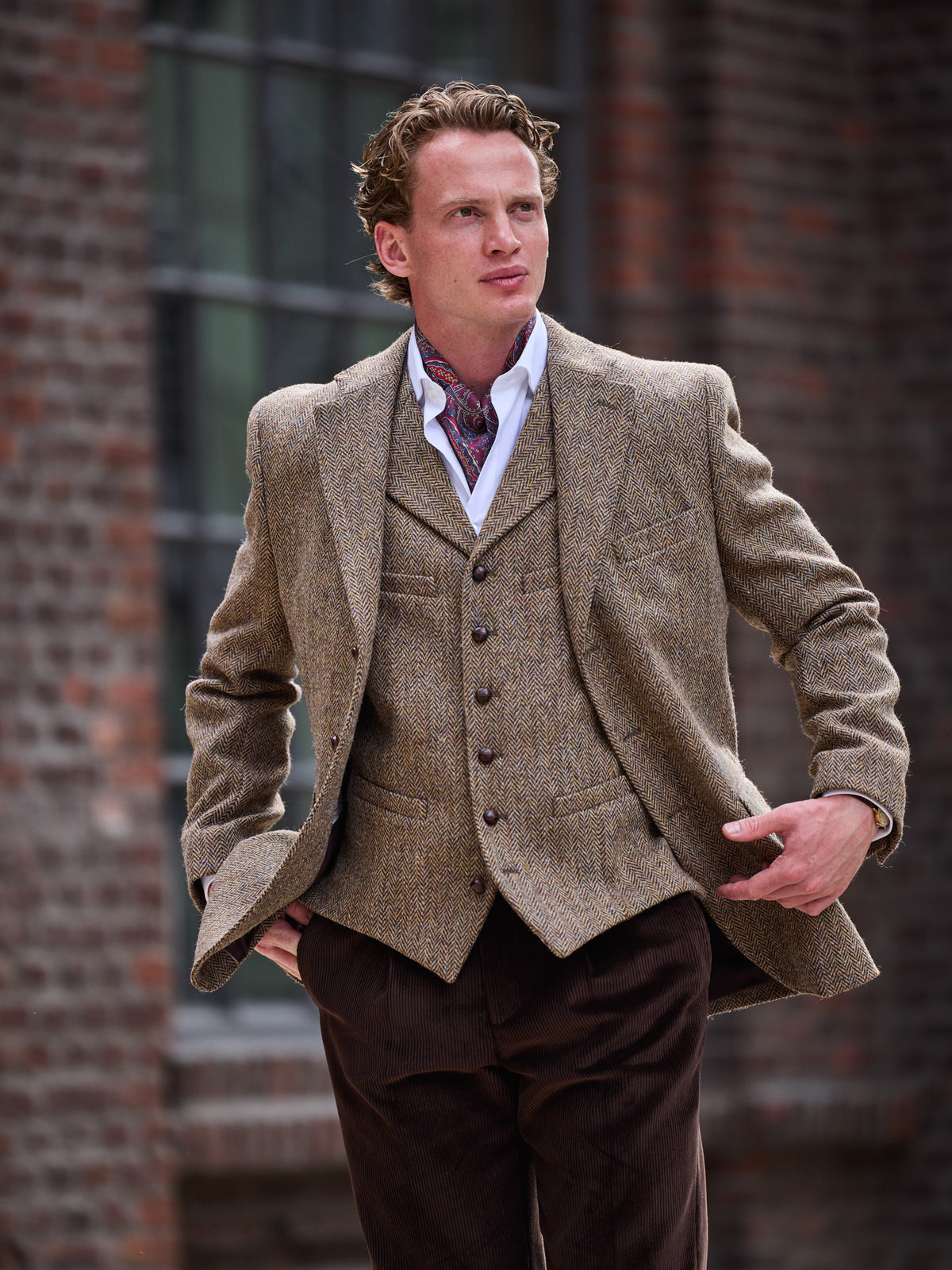 Tweed-Sakko Fischgrät Harris Tweed Green and Fawn über der Weste getragen, Hände in den Taschen — John Crocket