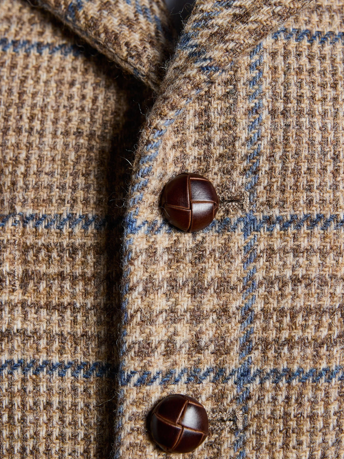 Tweed waistcoat in Magee Tweed, Sand, detail of lapels, leather buttons and Prince of Wales check with blue overcheck – John Crocket