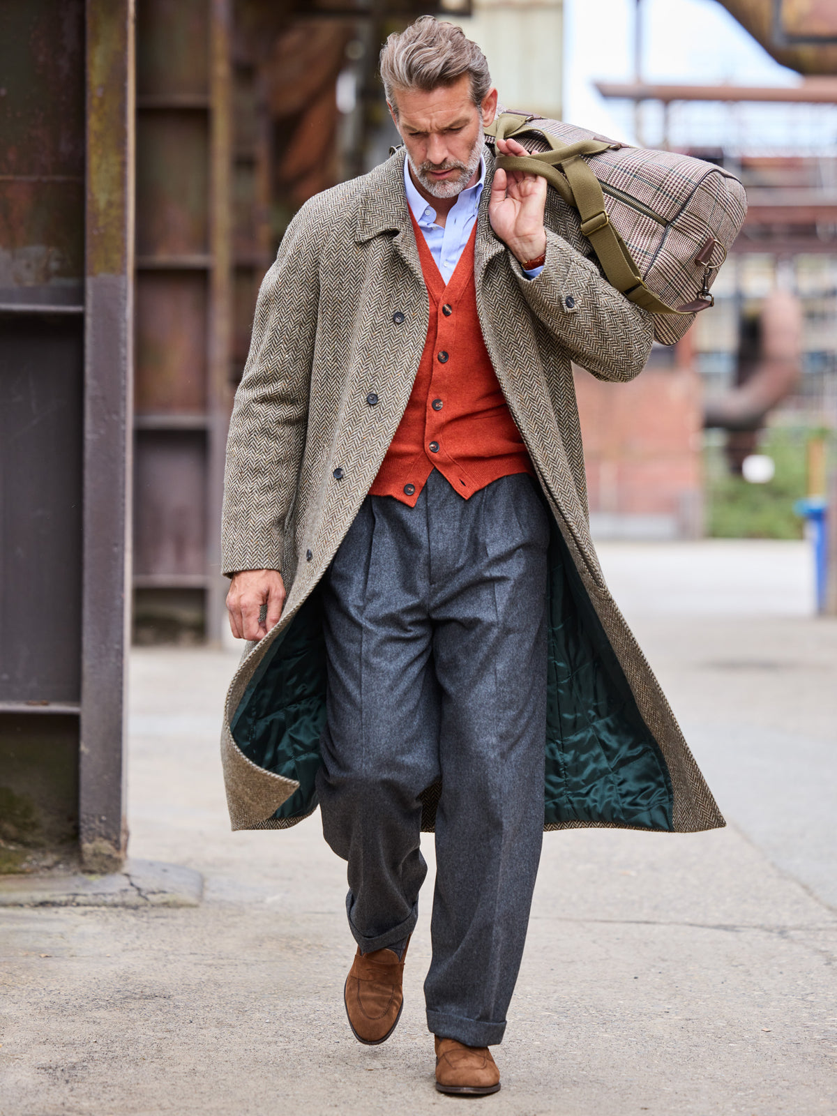 Raglanmantel Fischgrät John Hanly Tweed Olive Light Brown offen getragen mit Reisetasche — John Crocket