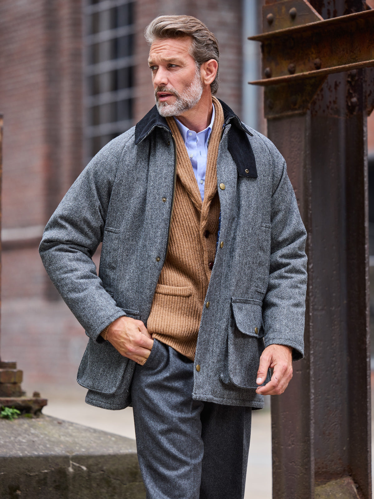 Oxford Jacke Fischgrät Moon Tweed Dark Grey offen über camelfarbener Strickjacke getragen — John Crocket